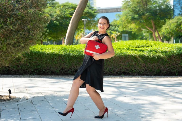 Dr. Angela Thomas in red high heels with red doctorbag in the park