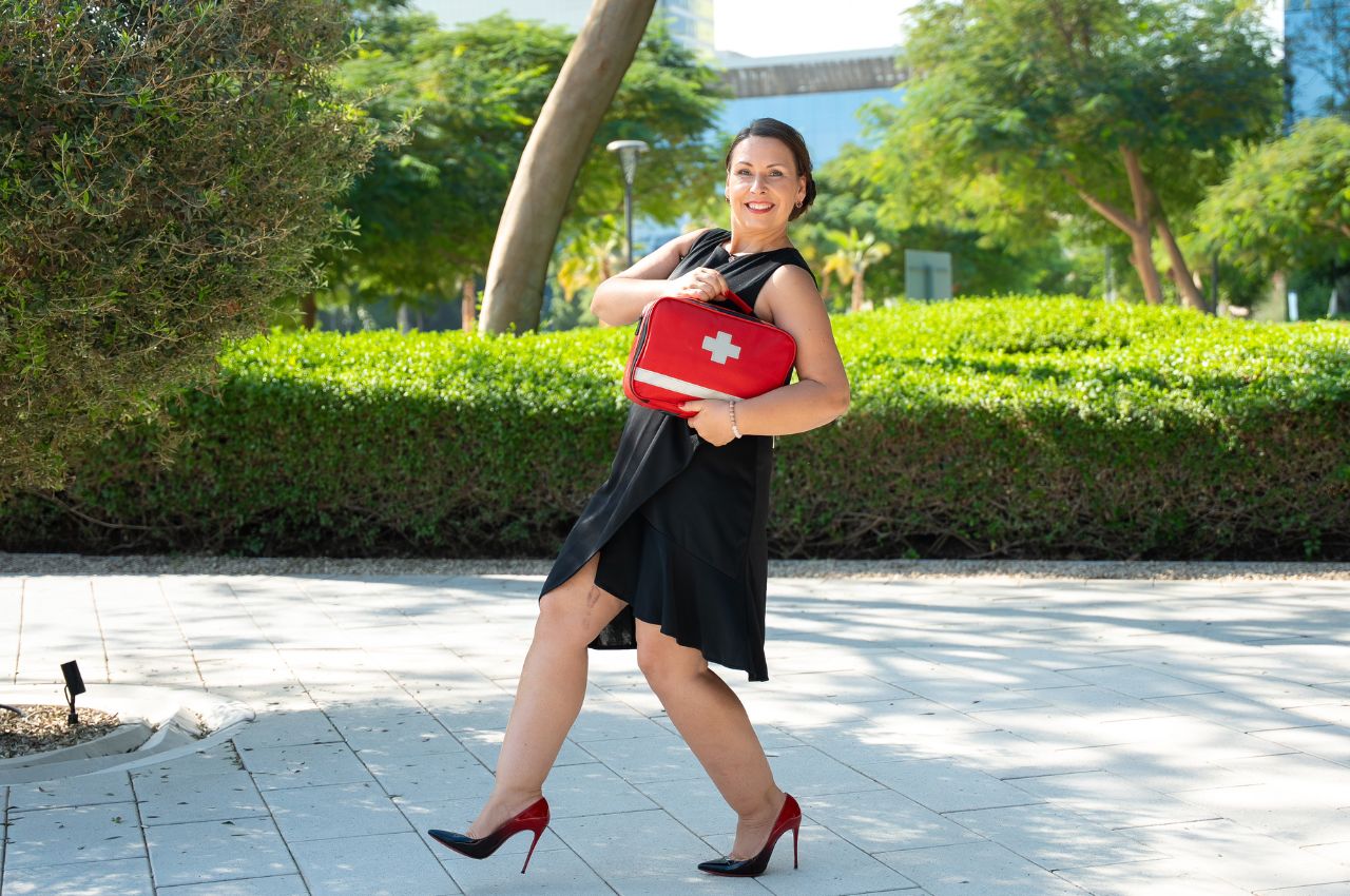 Dr. Angela Thomas in red high heels with red doctorbag in the park