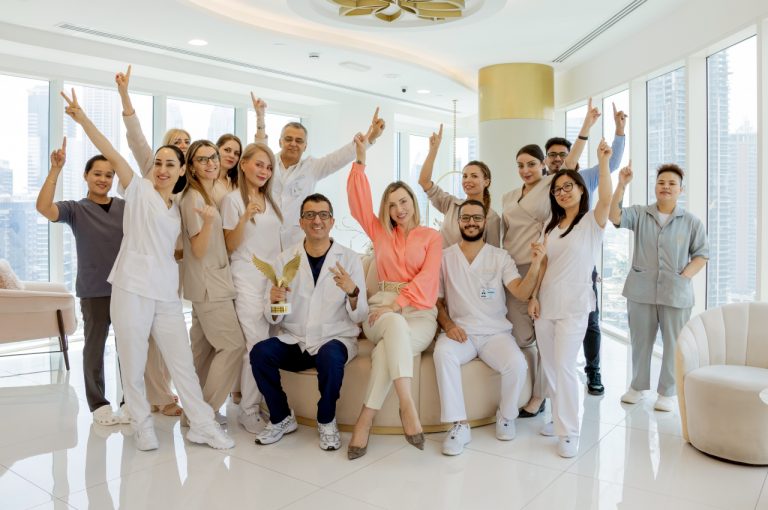 Medical team at Eden Aesthetics Clinic in Dubai posing together in a modern clinic interior.