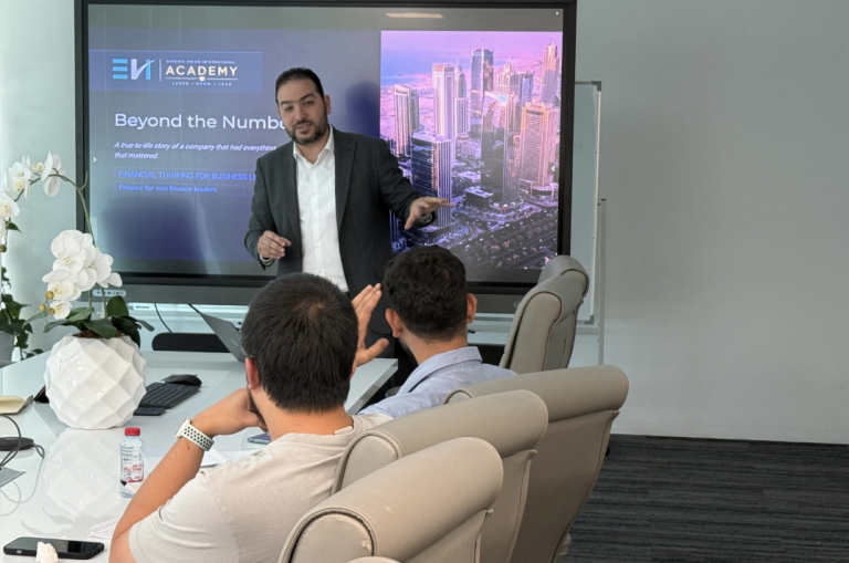 Business trainer delivering a practical financial leadership workshop to professionals in a conference room.