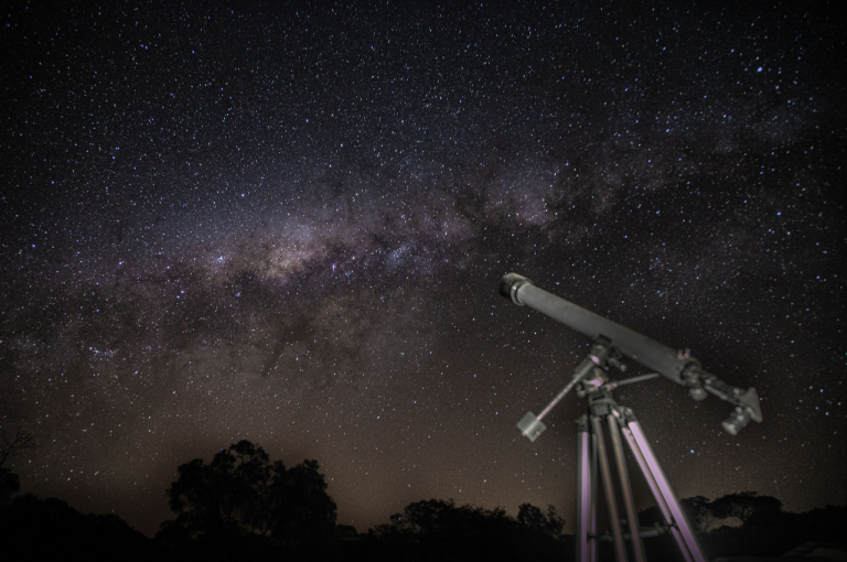 Telescope beneath the Milky Way and a star-filled night sky.